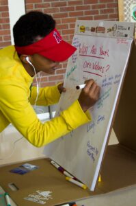 Student adding core value to flip chart