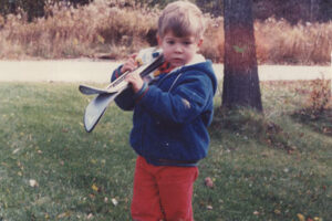 Ryan holding skis at 2 years old