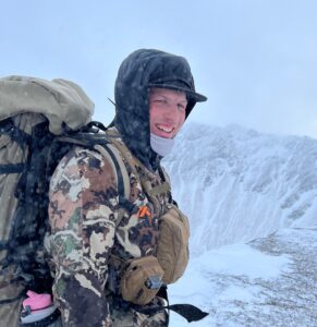 Carter Snow with backpack with Alaskan mountain in background